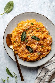 a bowl filled with pasta and topped with sage