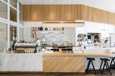 the interior of a restaurant with marble counter tops and bar stools