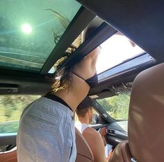 two people are sitting in the back seat of a car looking at an underwater tank