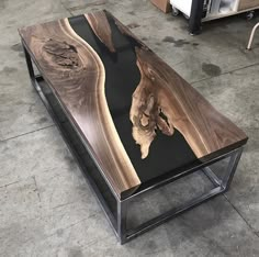 a coffee table made out of wood and metal with an artistic design on it's top