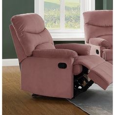 a pink recliner chair sitting on top of a hard wood floor next to a window