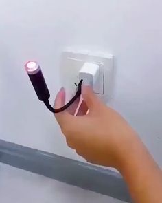 a hand holding a light switch with a cord attached to it