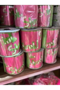 several rolls of pink and green tape are stacked on top of each other in a store