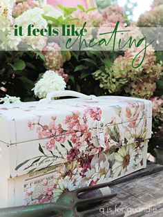 a suitcase sitting on top of a wooden table with flowers in the background and text overlay that reads, it feels like creating