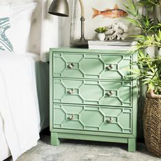 a green painted dresser next to a bed