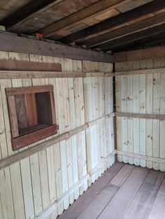 an empty room with wooden walls and flooring on the inside, in front of a window