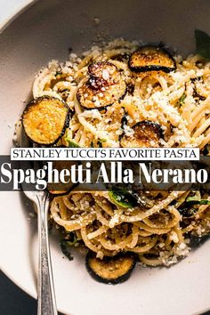 spaghetti with eggplant and parmesan cheese on top in a white bowl