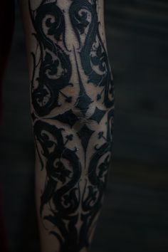 a close up of a person's leg with black and white tattoos on it