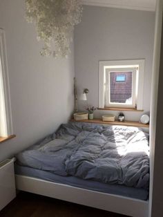 a bedroom with a bed, dresser and window