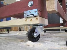 a close up of a wooden table with wheels on the bottom and bottom part of it