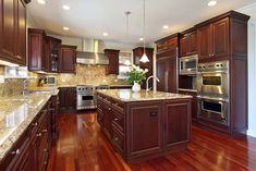 a large kitchen with wooden floors and granite counter tops