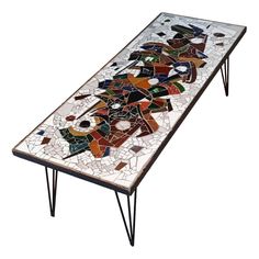 a mosaic table with hairpin legs is shown on a white background in this image