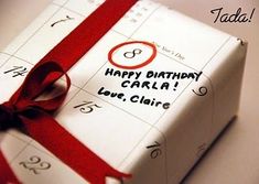 a birthday card wrapped in white paper with a red ribbon around it and the words happy birthday carla love claire