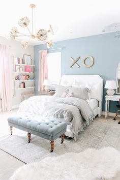 a bedroom with blue walls and white furniture