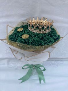 a white box filled with green roses and a gold crown