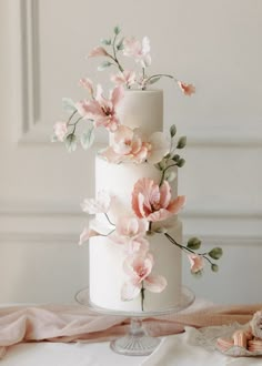 a white wedding cake with pink flowers on top