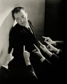 black and white photograph of five people pointing at something in the air with their fingers