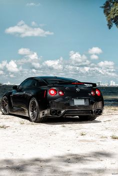 a black sports car parked on the beach