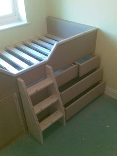 there is a bunk bed with drawers on the bottom and bottom shelves in front of it