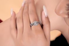 a woman's hand with a diamond ring on top of her finger and the other hand