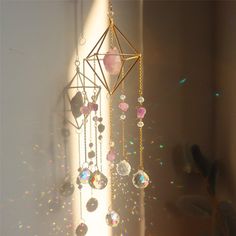 the sun shines brightly on a mobile with beads hanging from it