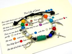 a bracelet with beads and charms is on top of a piece of paper that says the life of jesus