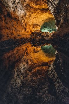 the water is reflecting the light in the cave