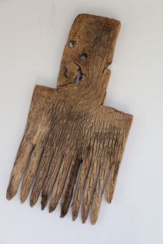 an old wooden comb with holes in the middle on a white background, it appears to have been carved from wood