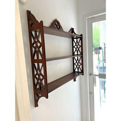 a wall mounted shelf in the corner of a room with an open door to another room