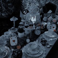 a table topped with lots of dishes covered in frosty icing next to a clock