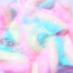 there is a pink, blue and yellow substance in the water that looks like candy