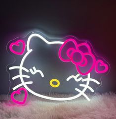 a hello kitty neon sign with hearts on it's head is shown in front of a black background