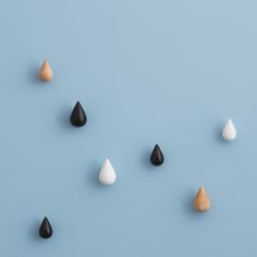 several different colored and black and white raindrops on a blue background