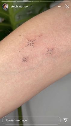 a person's arm with three small stars on the left side of their arm