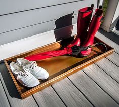 two pairs of red and white shoes sitting on top of a wooden tray next to each other