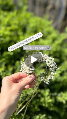 a person holding flowers with white stickers on their fingers and pointing to the camera