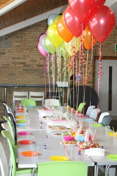 the table is set with many balloons and confetti