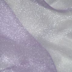 a close up view of some white and purple fabric with small dots on the top