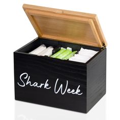 a wooden box filled with different types of toothpaste and other items that are labeled shark week