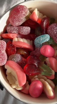 a bowl filled with gummy bears sitting on top of a table