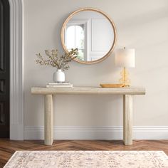 a table with a mirror on it in front of a door and a vase filled with flowers