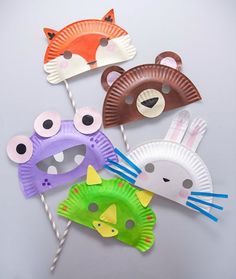 four paper plates with animal masks on top of each one and two straws in the shape of animals