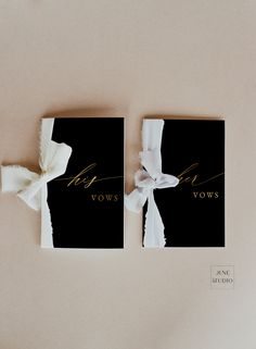 two black and gold wedding cards with white bows