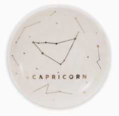 the capricorn zodiac sign on a white plate