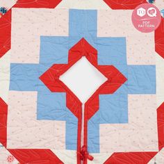 a red, white and blue quilt with an arrow on it