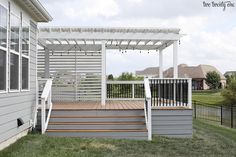 a white pergolan sitting on top of a wooden deck