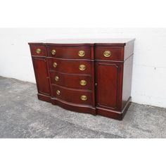 a wooden dresser with brass handles and drawers