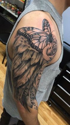 a man's arm with a butterfly and rose tattoo on the back of it