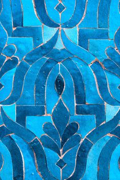 a close up view of a green and blue tile pattern with an intricate design on it