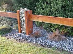 a wooden fence surrounded by rocks and grass